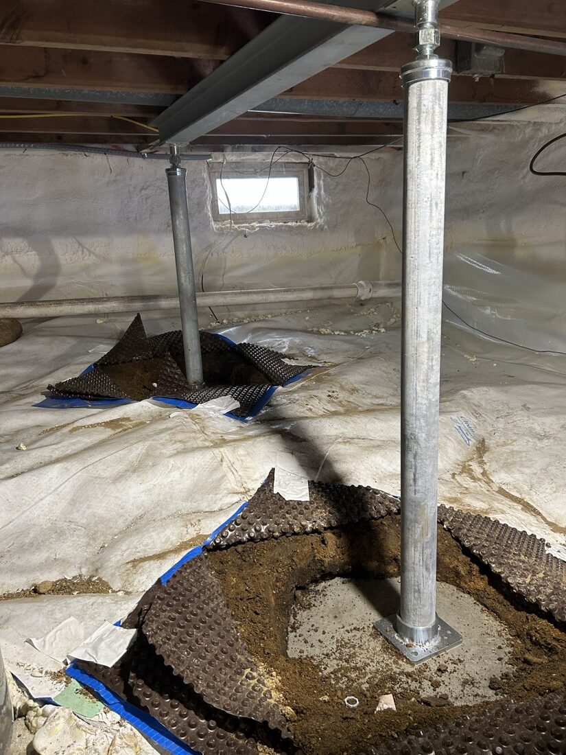 Two new galvanized adjustable columns on poured concrete footings. CRAWL SPACE, not a basement -- sealed vapour barrie