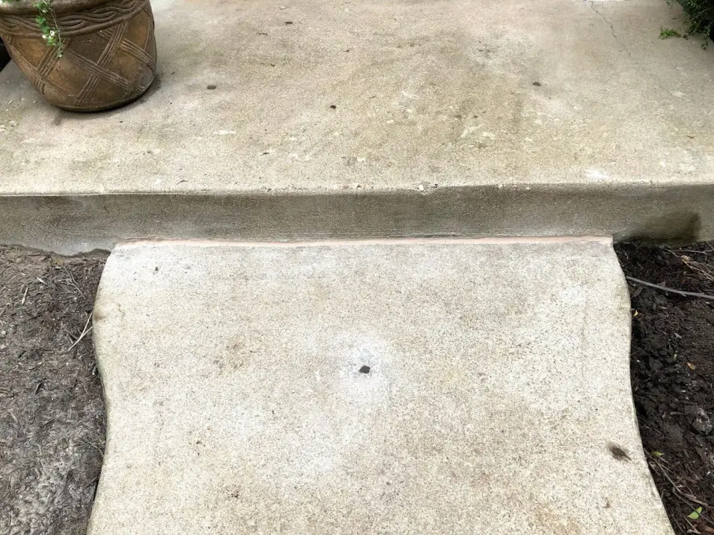 Low concrete step beneath a higher patio edge