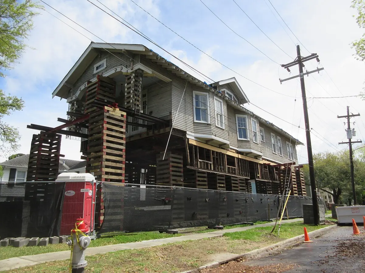 Elevated house held on timber cribbing while work continues below