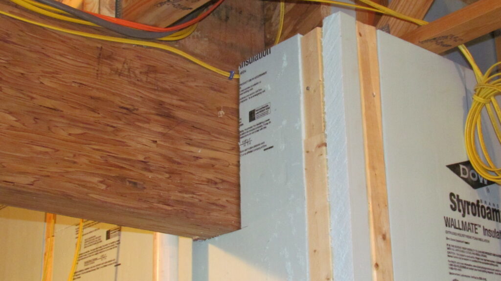 Laminated support beam in a basement with surrounding insulation